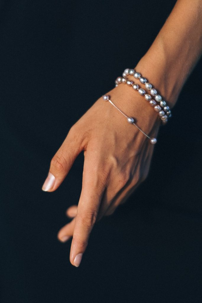person wearing silver bracelet and gold ring